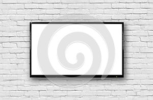 LCD TV with a thin black frame hanging on a white brick wall. Blank white screen. Isolated on white background