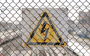 Ld aged rusty triangle metal plate with High voltage warning sign.