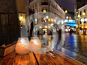 Vacanza stagione notte strade bar di legno tavolo due candela tazza  la città notte  strade sfocato la luce vecchio 