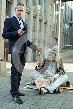 Lderly rich businessman giving some money to poor man