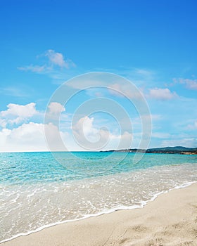 Le Bombarde beach under a blue sky with clouds