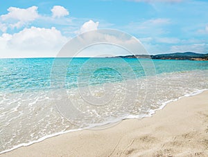 Le Bombarde beach under a blue sky with clouds