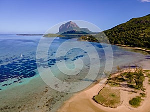 Le Morne beach Mauritius,Tropical beach with palm trees and white sand blue ocean and beach beds with umbrella,Sun