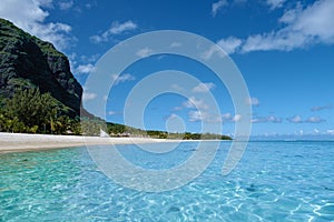 Le Morne beach Mauritius,Tropical beach with palm trees and white sand blue ocean and beach beds with umbrella,Sun