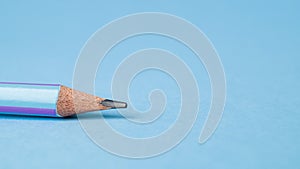 Lead of blue pencil. Sharpened simple pencil on a blue background. Sharpened pencil tip.