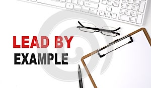 LEAD BY EXAMPLE Concept. Calculator,pen and glasses on white background