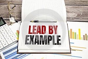 lead by example sign on notepad on the white background