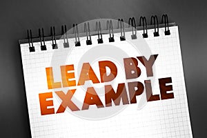 Lead By Example text on notepad, concept background