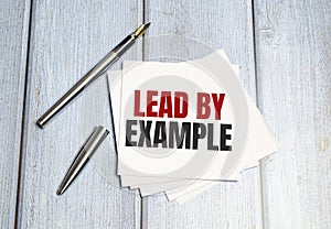 lead by example text write on white paper