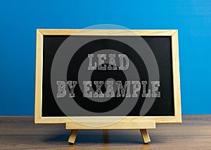 LEAD BY EXAMPLE wrote on chalkboard with graph