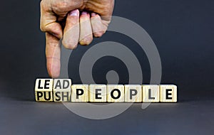 Lead or push people symbol. Concept word Lead people and Push people on wooden cubes. Beautiful grey table grey background.