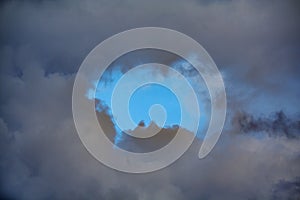 Leaden storm clouds with blue sky in center