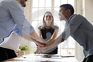 Leader motivating young mixed race colleagues before starting new project.