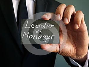 Leader vs manager inscription on a piece of paper