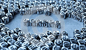 Leader - Word from Metal Blocks on Paper