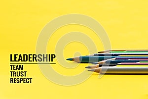 Leadership business concept. Blue color pencil lead other color with word Leadership, team, trust and respect on yellow background