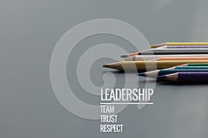 Leadership business concept. Gold color pencil lead other color with word Leadership, team, trust and respect on black background