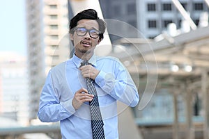 Leadership business concept. Portrait of confident young Asian businessman walking and touching necktie with hands between go to o