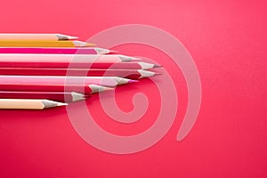 Leadership business concept. red color pencil lead other color on pink background