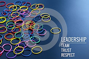 Leadership business concept. yellow color rubber band lead other color with word Leadership, team, trust and respect