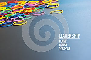 Leadership business concept. yellow color rubber band lead other color with word Leadership, team, trust and respect