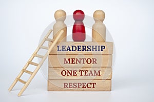 Leadership concept with doll figures on top of wooden blocks with wooden ladder