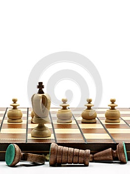 Leadership Concept: King Chess Piece With Pawns And Defeated Chess Pieces