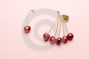 leadership concept. red cherry group and leader near it on a pink background