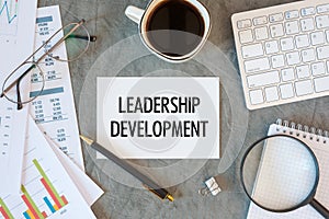 Leadership Development is written in a document on the office desk, coffee, diagram and keyboard