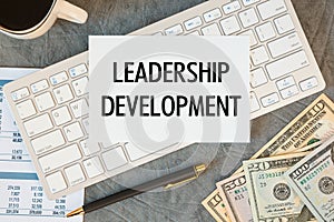 Leadership Development is written in a document on the office desk, coffee, money and keyboard