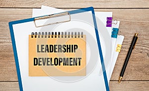 Leadership Development is written on a notepad on office desk