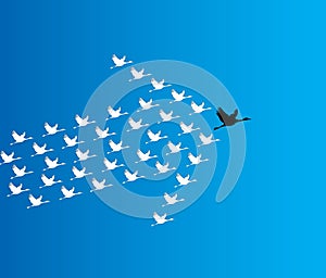 Leadership and Synergy Concept Illustration : A number of Swans flying against a deep blue sky