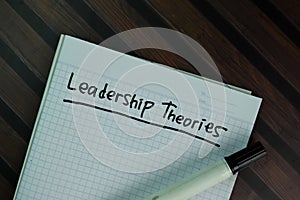 Leadership Theories write on a book isolated on Wooden Table