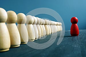 Leadership training concept. Line of figurines and red one opposite