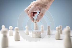 Leadership wooden business team with one person standing out from the crowd on podium