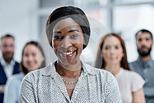 Leading a dedicated team to their next big success. Portrait of a businesswoman standing in an office with her