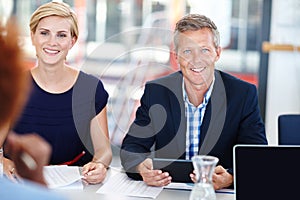 Leading his team with expertise. A mature male manager sitting in a meeting with his team.