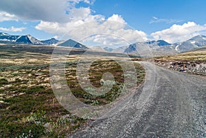 Leading lines and gravel road towards mountains