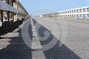 Leading lines of railings and shadows of long wharf photo
