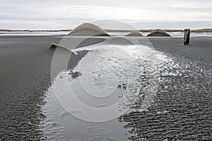 Leading lines towards sandy dunes on the black sandy textured beach of Stokksnes in the Hofn area in Iceland