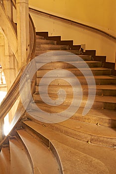 Leading to the top. An ornate staircase spiralling inside a building.