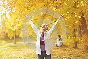 Leaf fall, happy woman in the autumn park