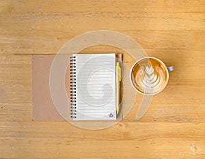 Leaf latte art coffee and notebook with pen