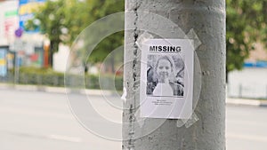 Leaflet about the missing child hanging on a pole,slow mo