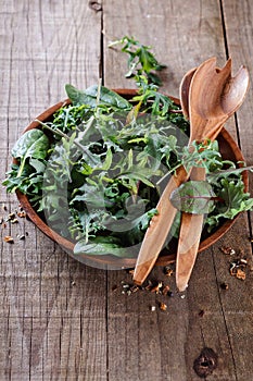 Leafy green mix over rustic wooden background