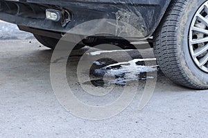 Leakage of antifreeze on the asphalt from damaged car