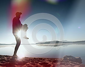 Leakage of light in the lens. . Running man. Sportsman run, jogging guy during the sunrise above sandy beach.