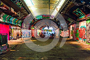 London, UK/Europe; 21/12/2019: Leake Street, underground tunnel with graffiti covered walls in London. Scene with pedestrians and