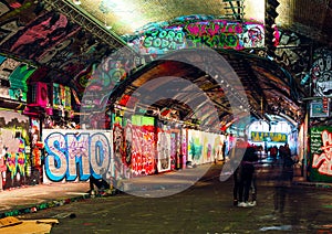 London, UK/Europe; 21/12/2019: Leake Street, underground tunnel with graffiti covered walls in London. Scene with pedestrians and