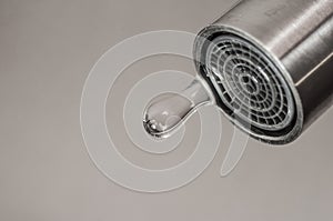 Leaking tap with a dripping drop of water. Call plumbing to eliminate leaks